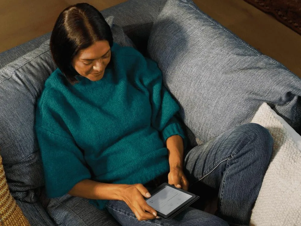 Una mujer lee en el sofá con el Kindle de 6 pulgadas de 2026