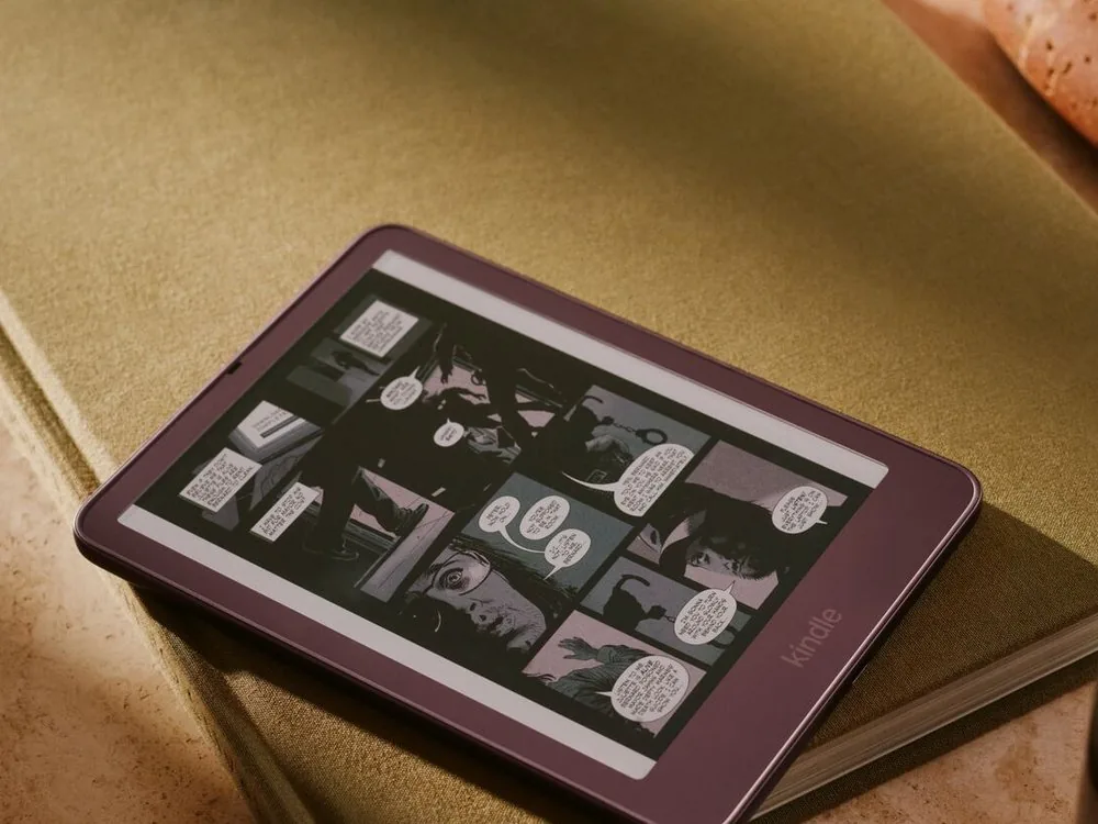 Un Kindle Colorsoft de 2026 con un cómic en color en la pantalla, sobre unos libros